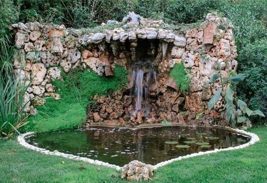 Una cascada con un estanque delante de ella.