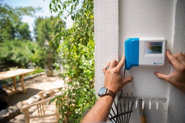 Una persona está instalando un dispositivo en una pared.