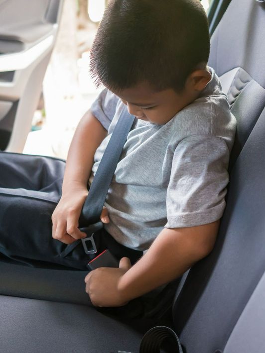 Enfant en voiture qui attache sa ceinture