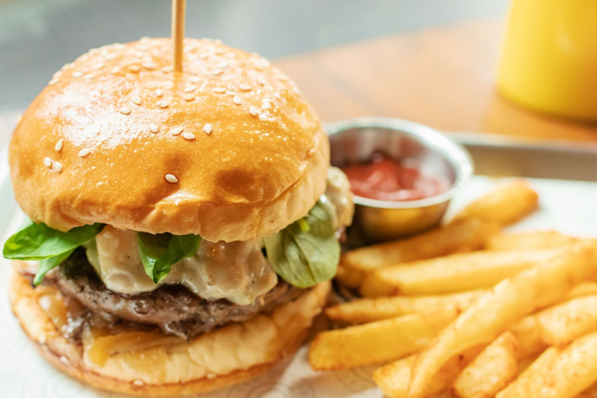 Un primer plano de una hamburguesa y papas fritas en una mesa.