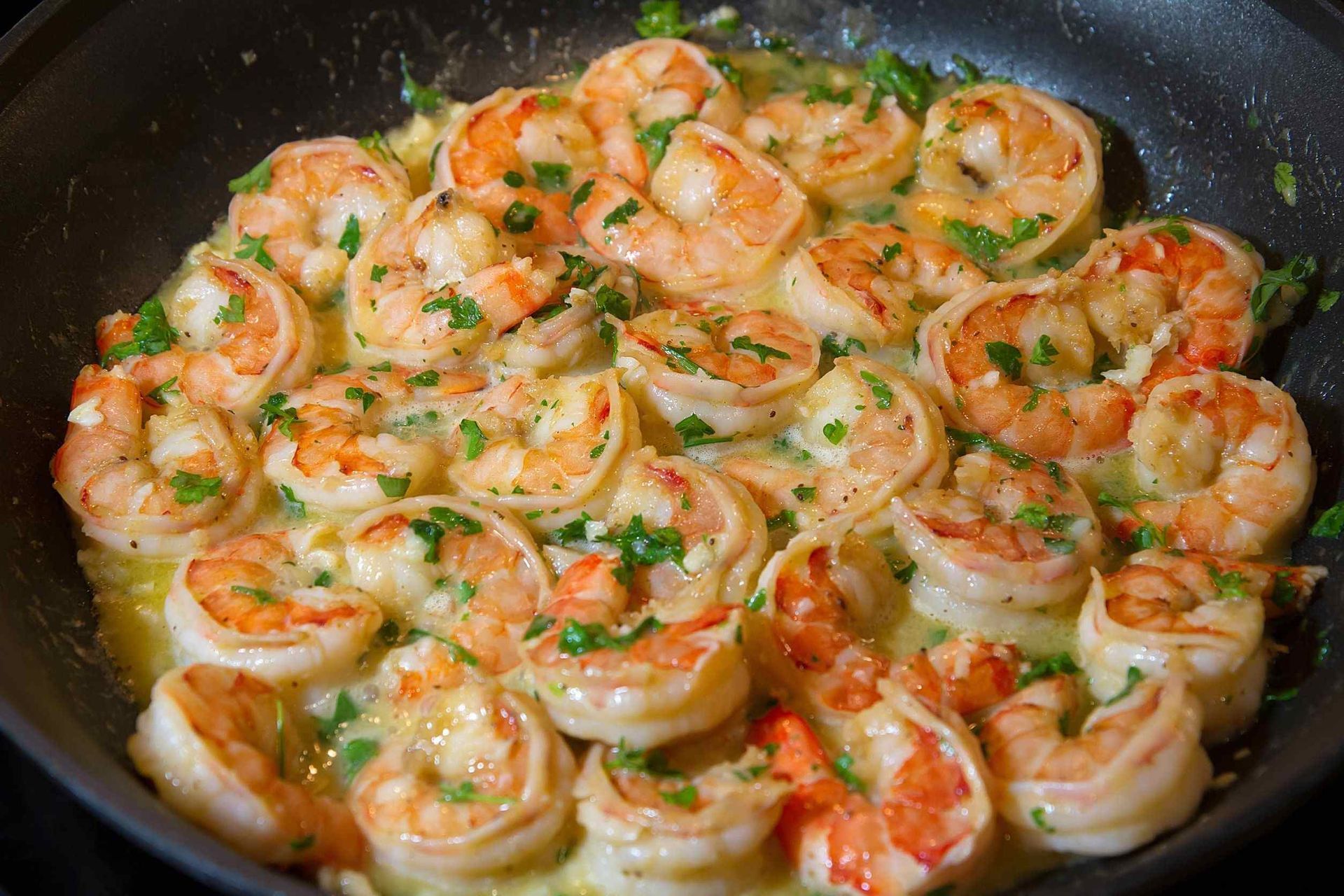 Los camarones se cocinan en una sartén sobre una estufa.