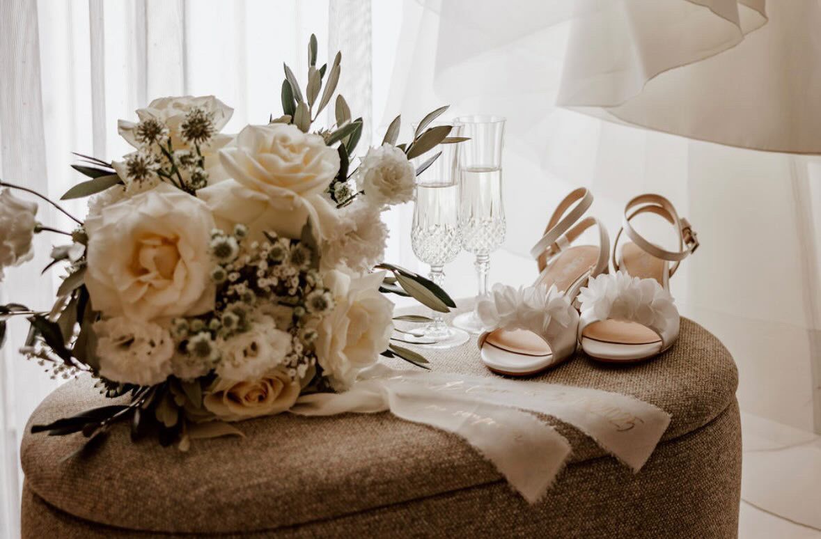 Brautstrauß mit weißen Rosen und Hochzeitsschuhen als romantische Hochzeitsdekoration