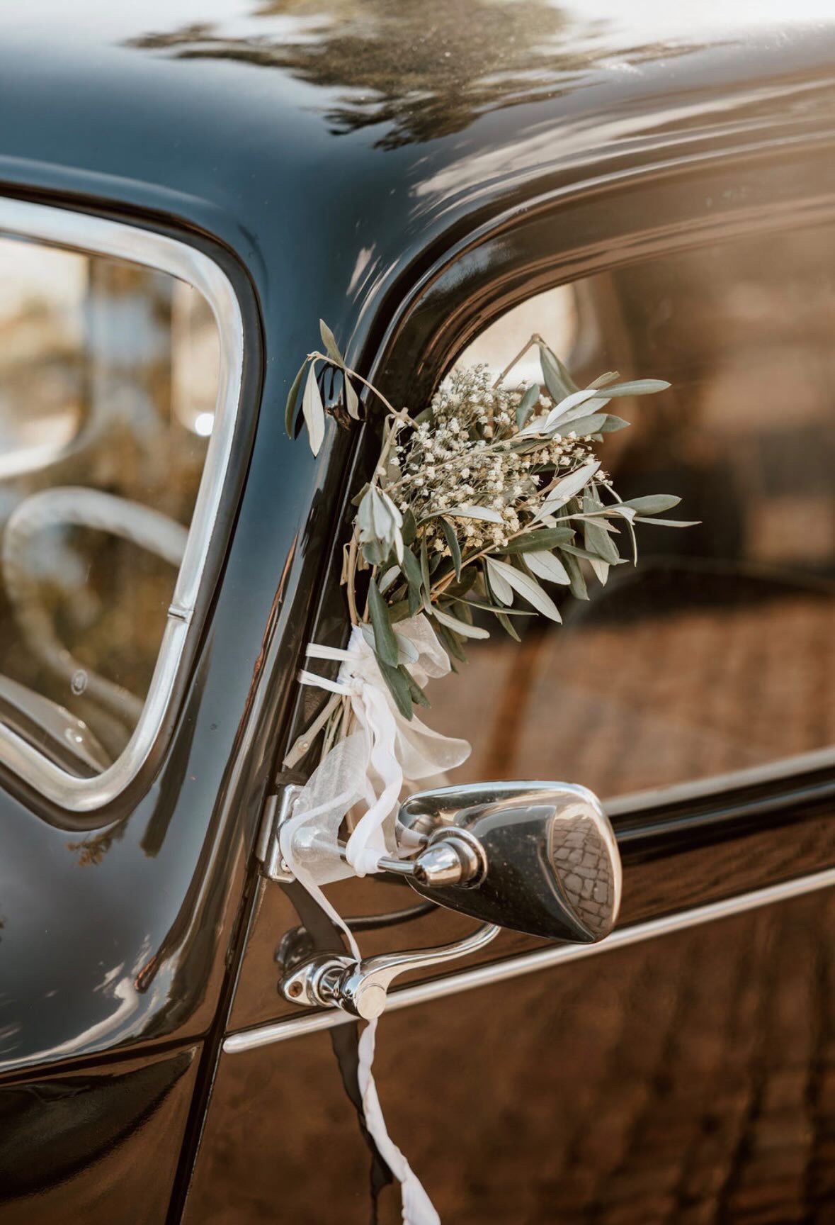 Autoschmuck mit weißen Blumen am Hochzeitsauto