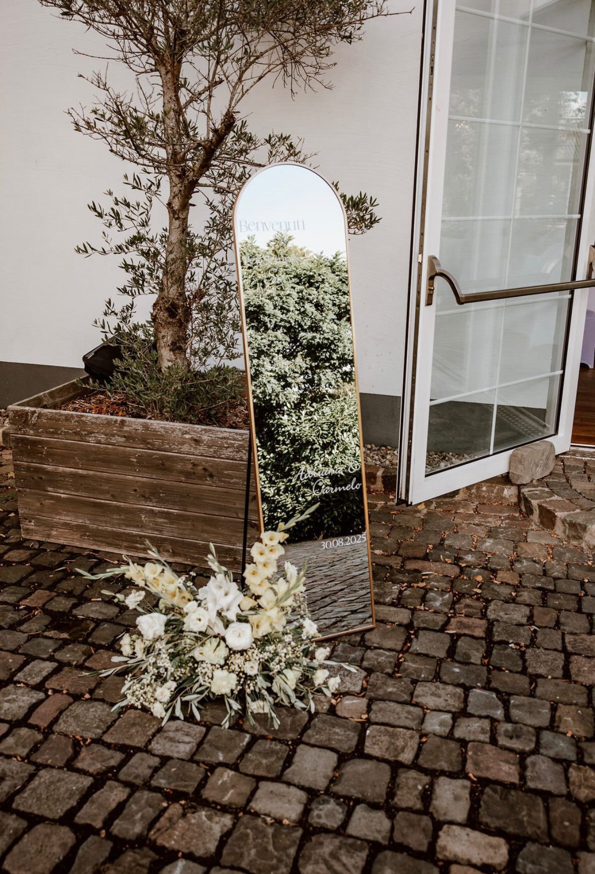 Hochzeitsspiegel mit Bogenform im Garten als dekoratives Element der Hochzeitslocation