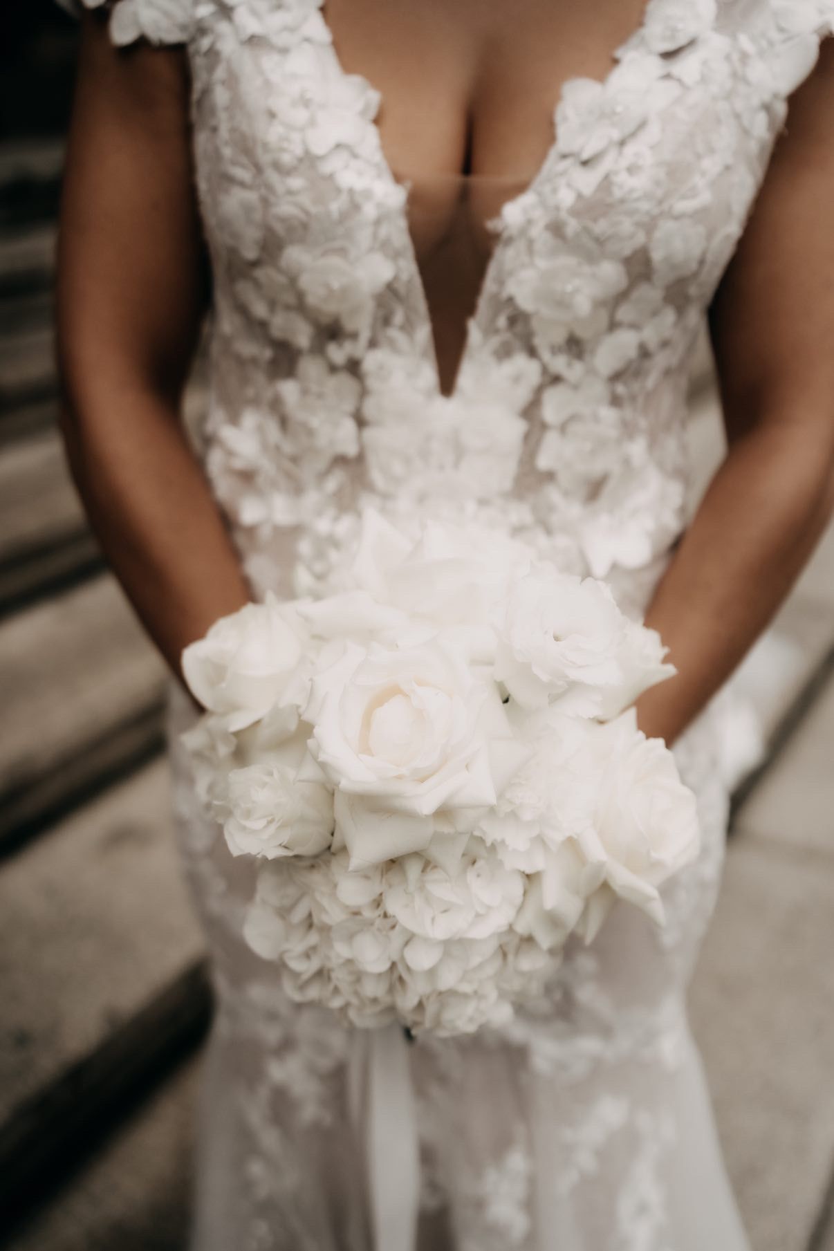 Braut mit Spitzenkleid als Detailaufnahme bei romantischer Hochzeit