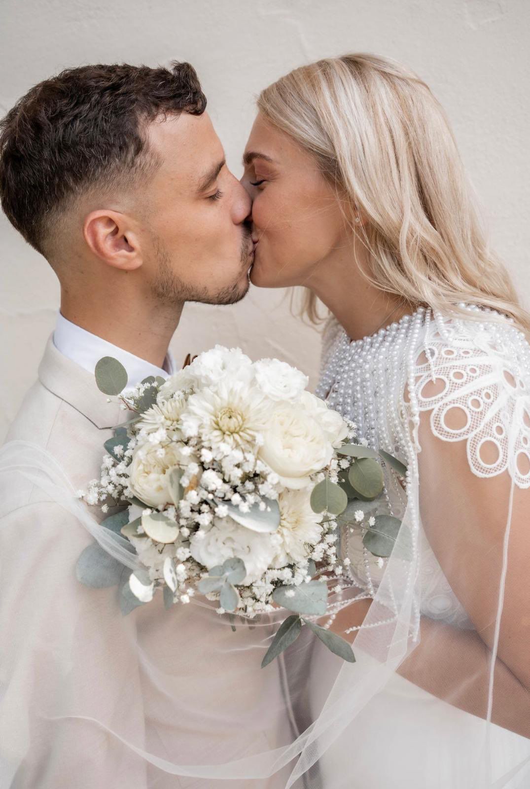 Brautpaar küsst sich romantisch bei Hochzeit