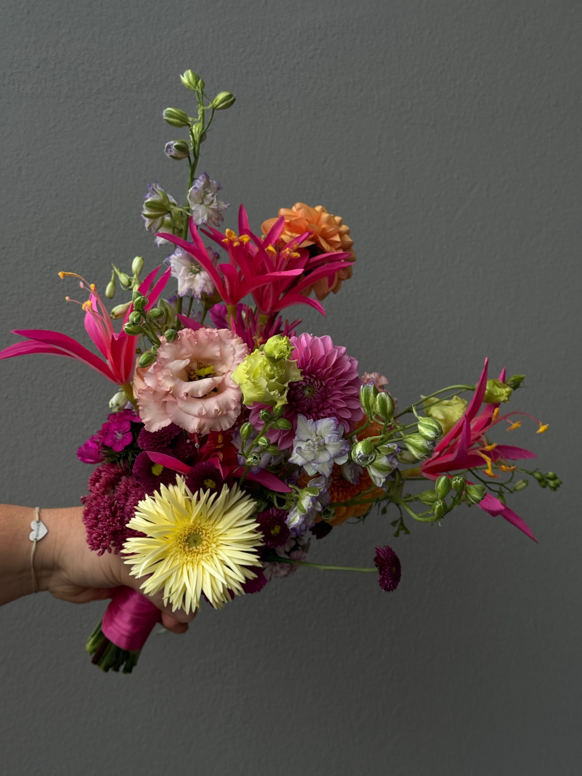 Bunter Strauß mit exotischen Blüten in Pink und Orange, modern inszeniert
