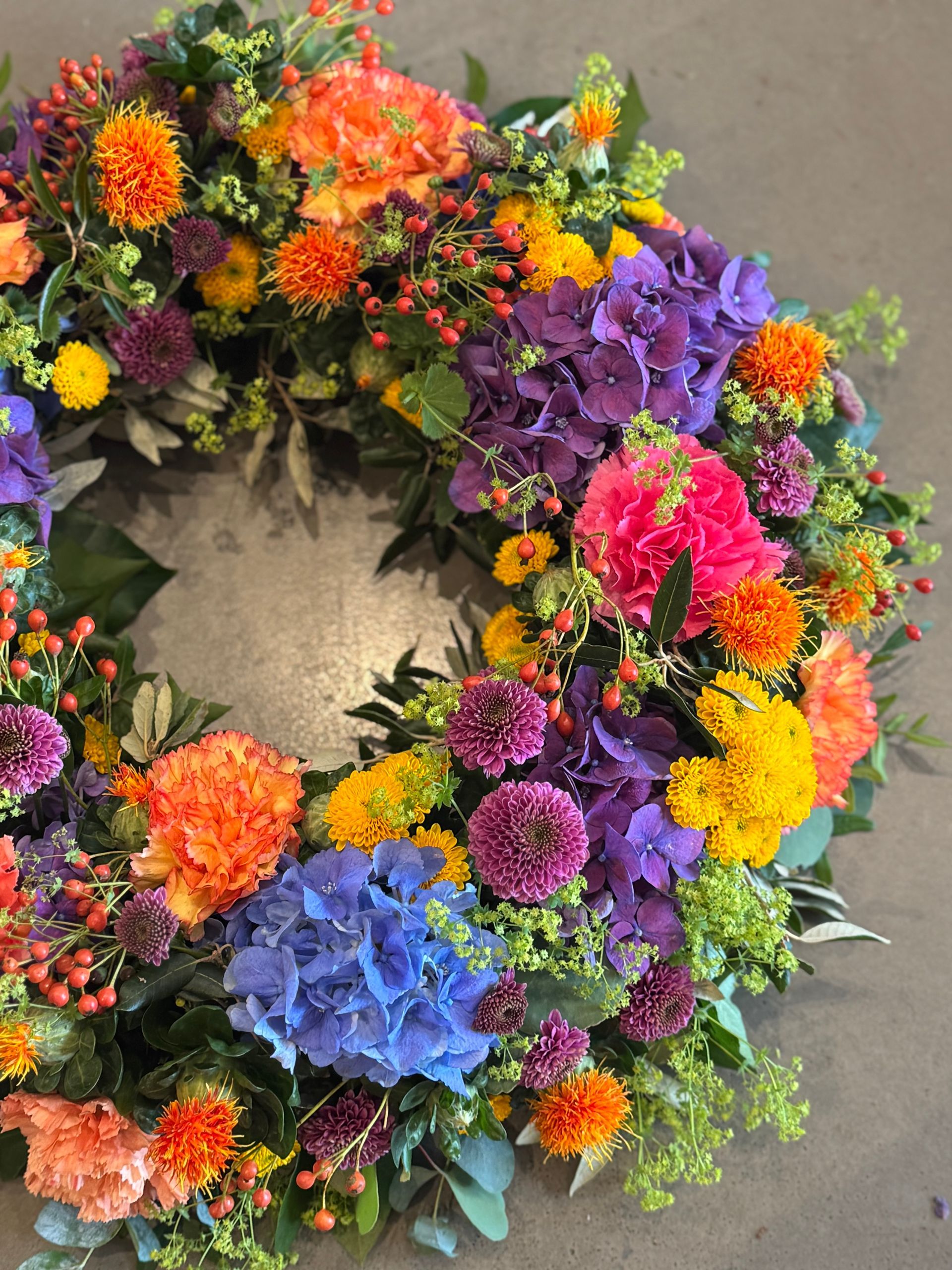 Bunter Kranz mit Hortensien und saisonalen Blumen, lebendig gestaltet