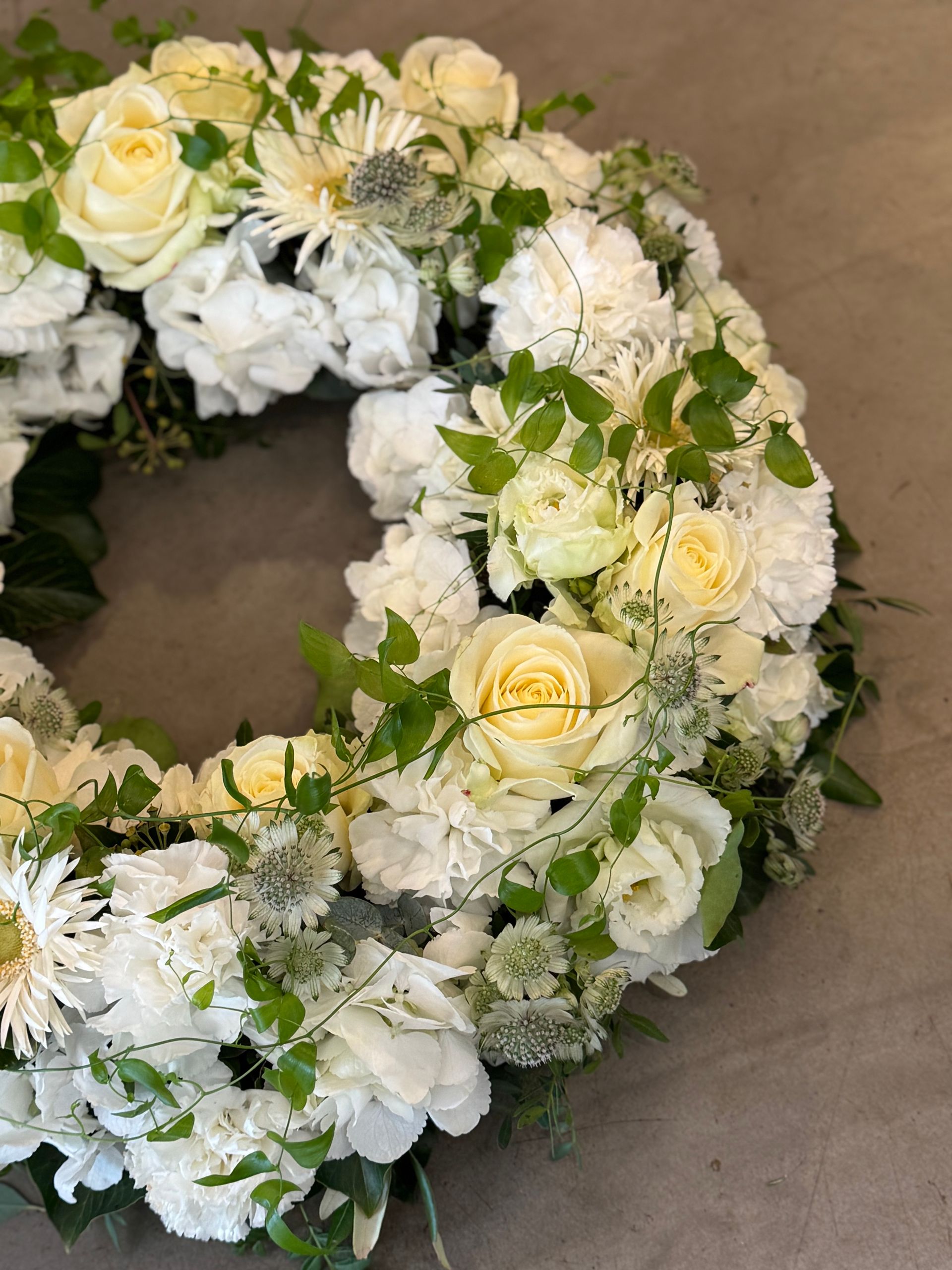Detail eines weißen Kranzes mit Rosen und Eukalyptus, fein gebunden
