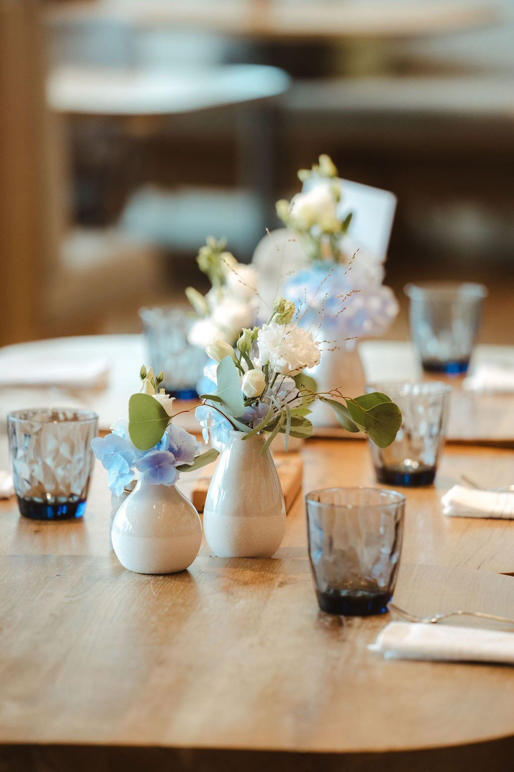 Kleine Blumenvasen als Tischdekoration bei Hochzeit