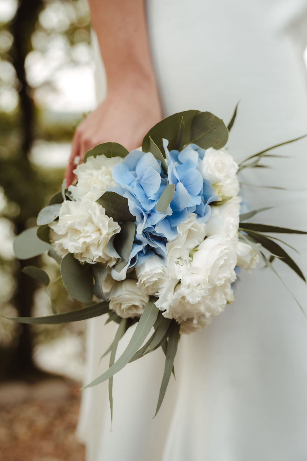 Braut hält Brautstrauß mit Hortensien und weißen Rosen