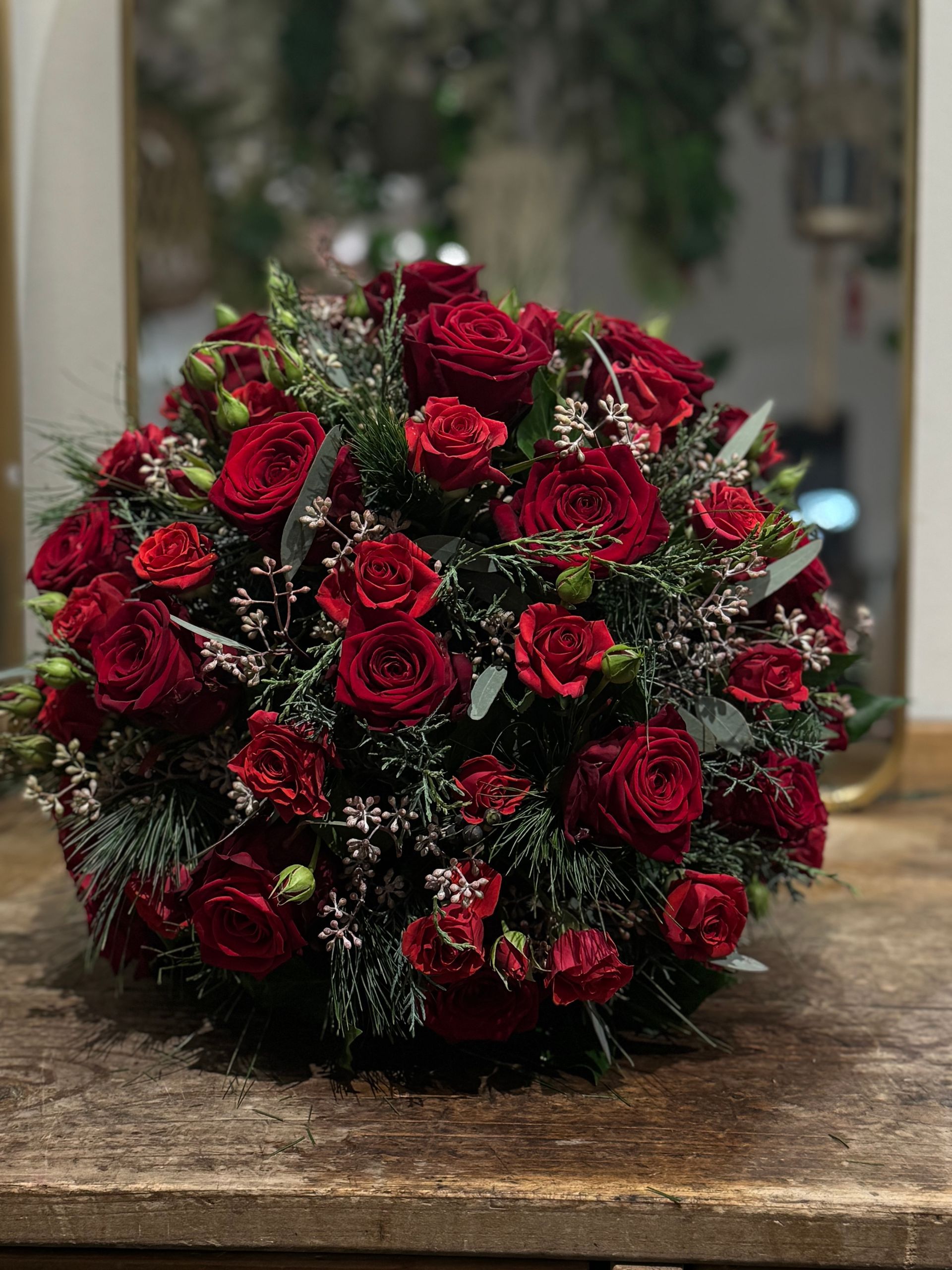 Roter Rosenkranz mit Tannengrün, klassischer Grabschmuck für Trauerfeier