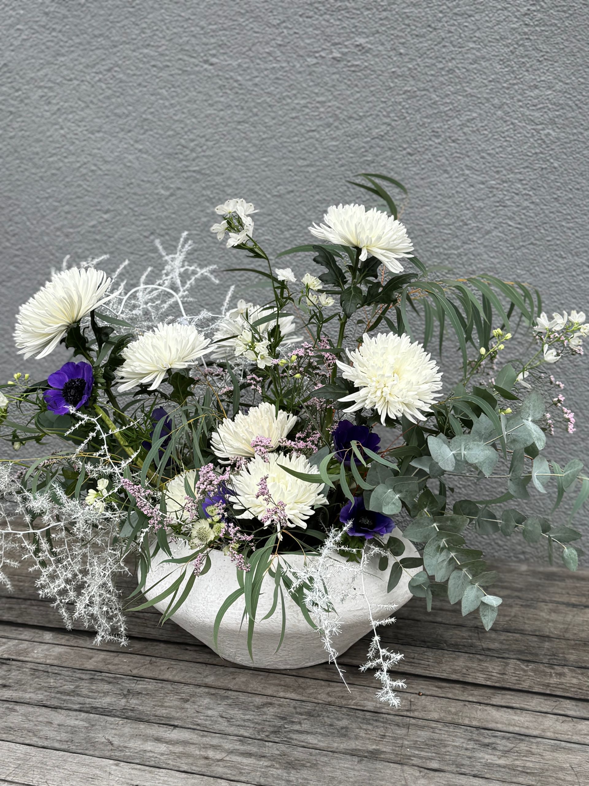 Schlichte Blumendeko mit weißen Chrysanthemen und zarten Zweigen