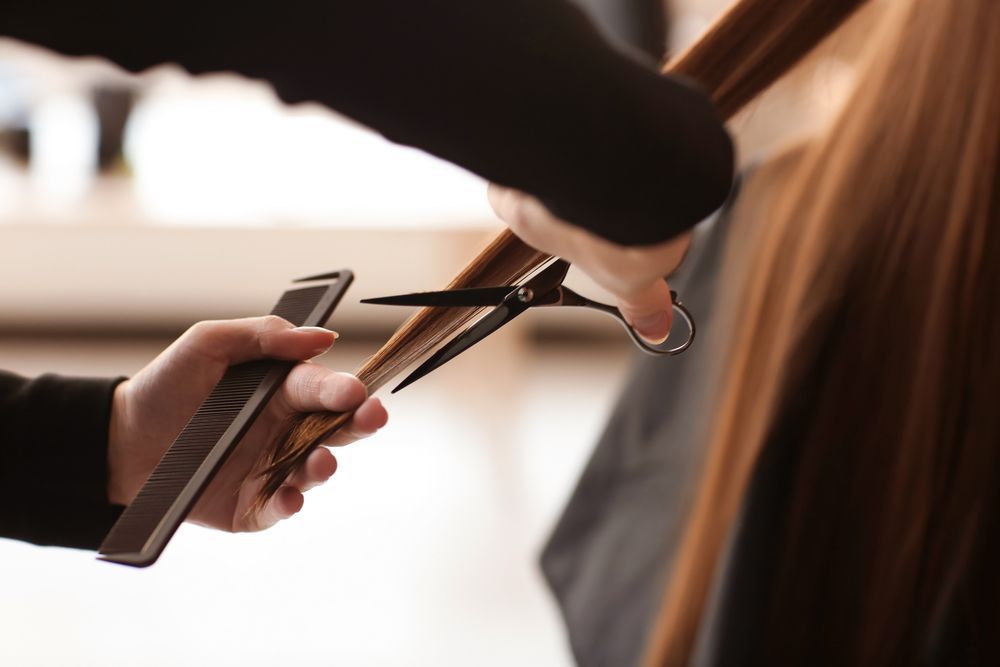 Una mujer se está cortando el pelo en la peluquería.