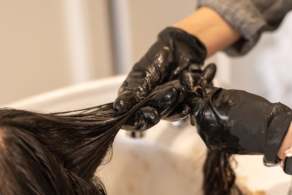 Una mujer se está tiñendo el pelo en un salón.