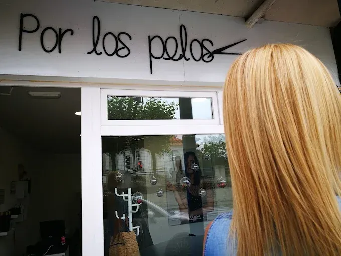 Un peine, tijeras, cepillos y una máquina cortadora de pelo sobre una superficie blanca.