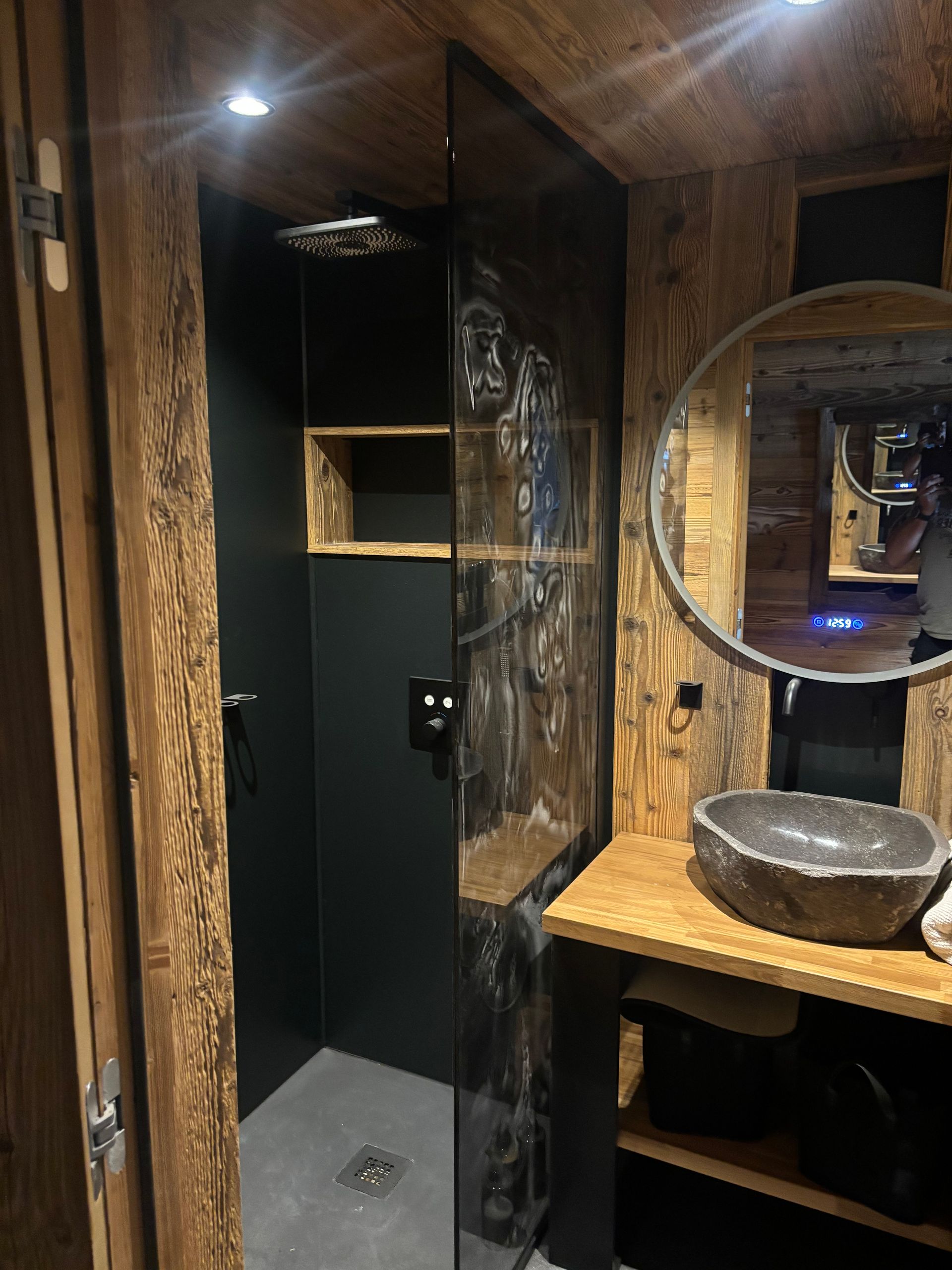 Salle de bains créée par le professionnel avec une ambiance sombre et bois