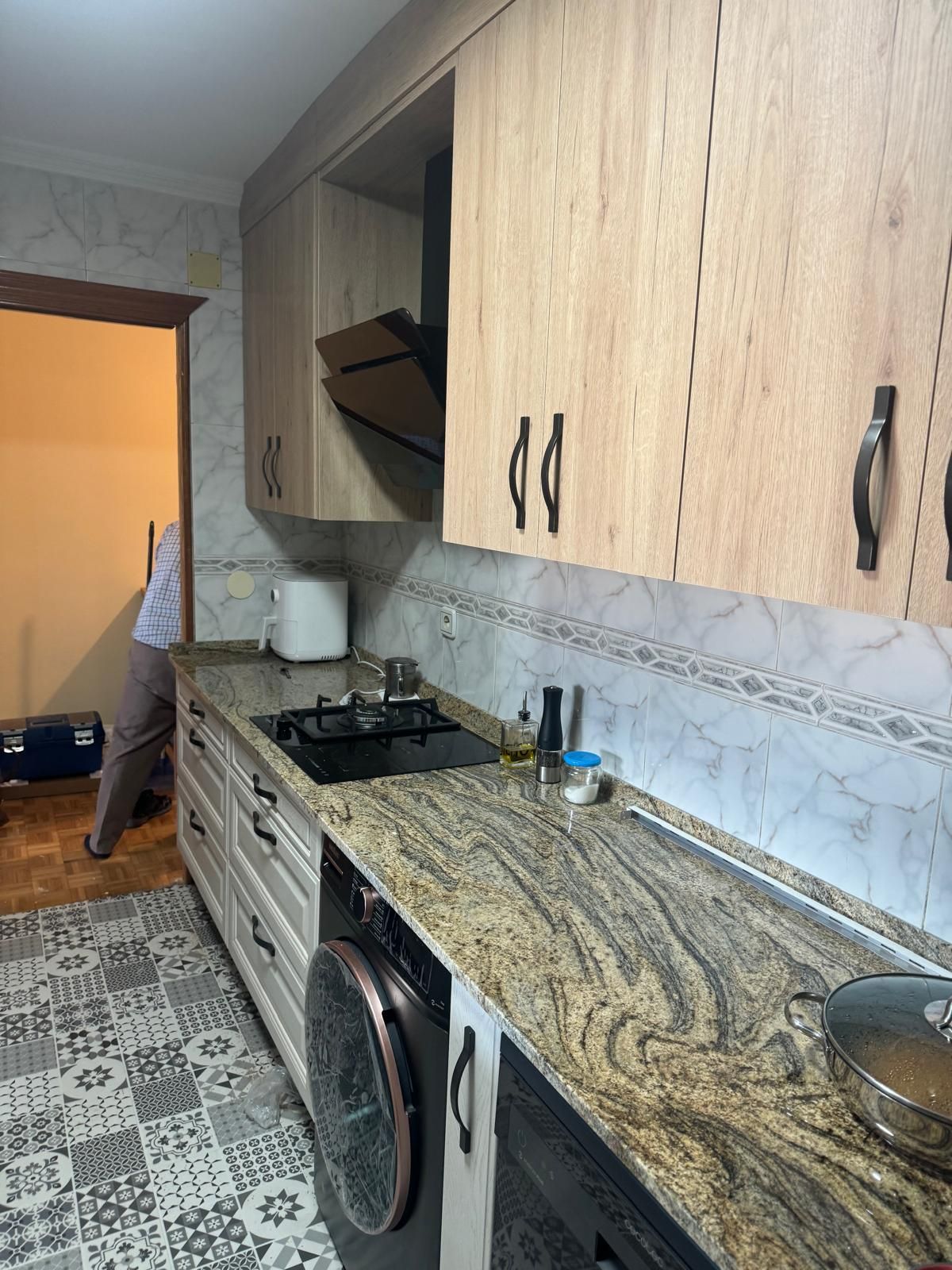 Una cocina con encimeras de granito y gabinetes de madera.