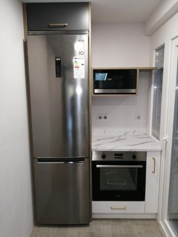 Una cocina con refrigerador de acero inoxidable y horno