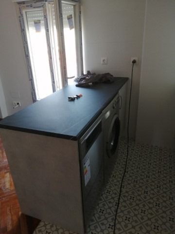 Una cocina con lavadora y lavavajillas en la encimera.