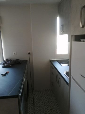 Una cocina con frigorífico, fregadero y lavavajillas.