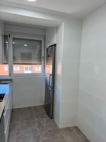 Una cocina con refrigerador de acero inoxidable y ventana.