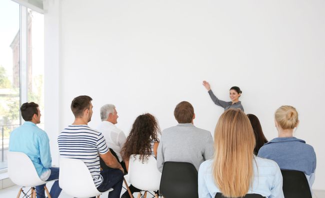 eine Frau hält eine Präsentation vor einer Gruppe von Menschen