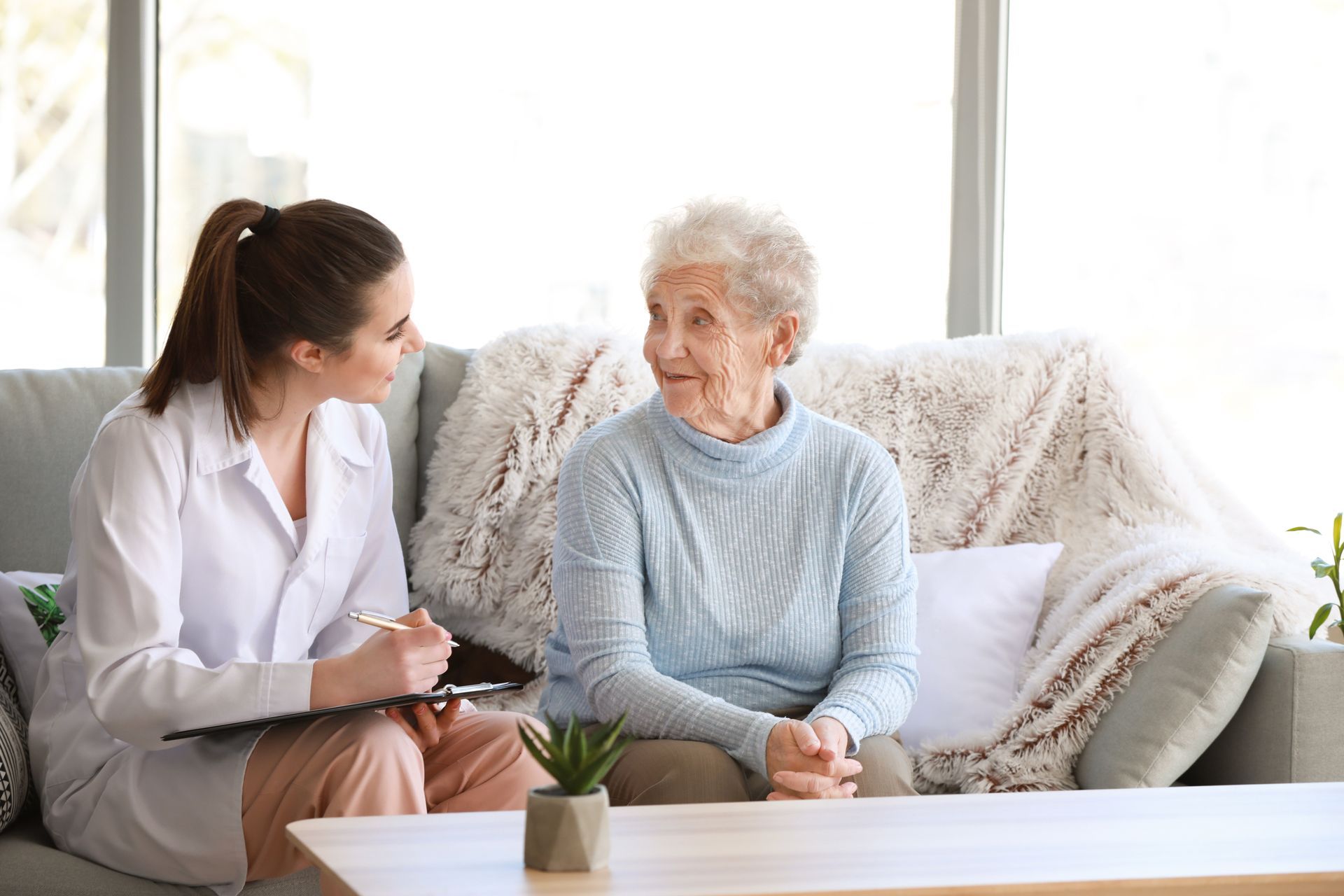 eine Frau sitzt auf einer Couch und spricht mit einer älteren Frau