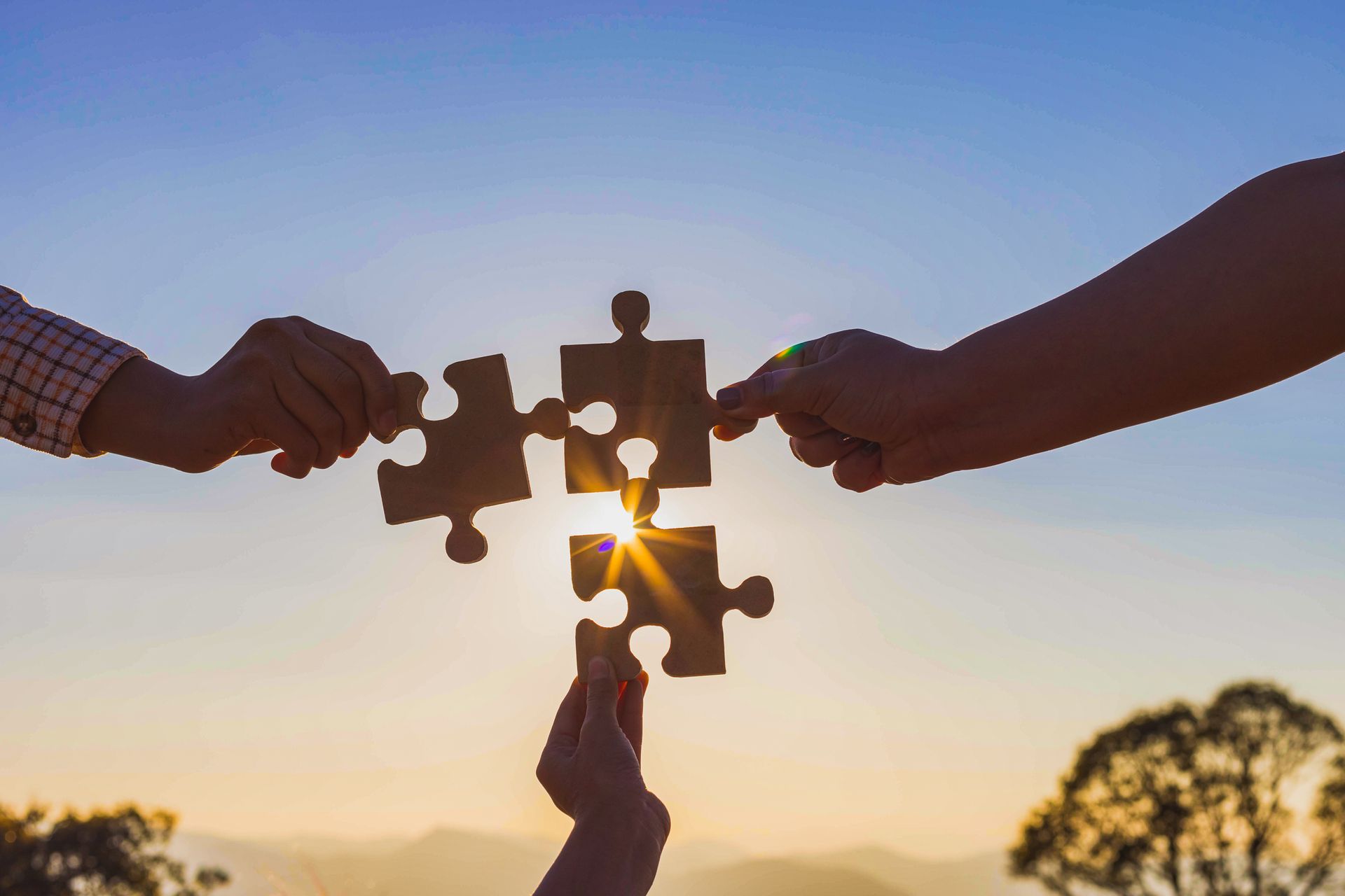 eine Gruppe von Menschen hält Puzzleteile in ihren Händen