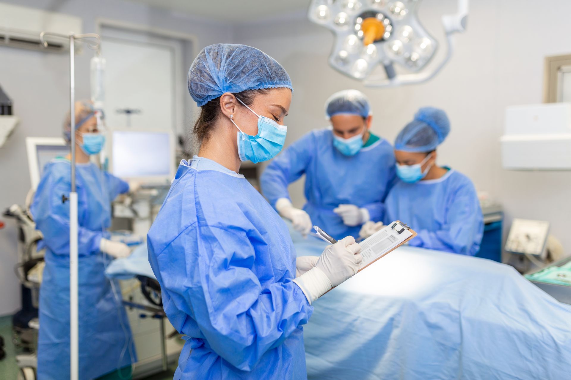 ein Chirurg schreibt auf ein Klemmbrett während einer Operation