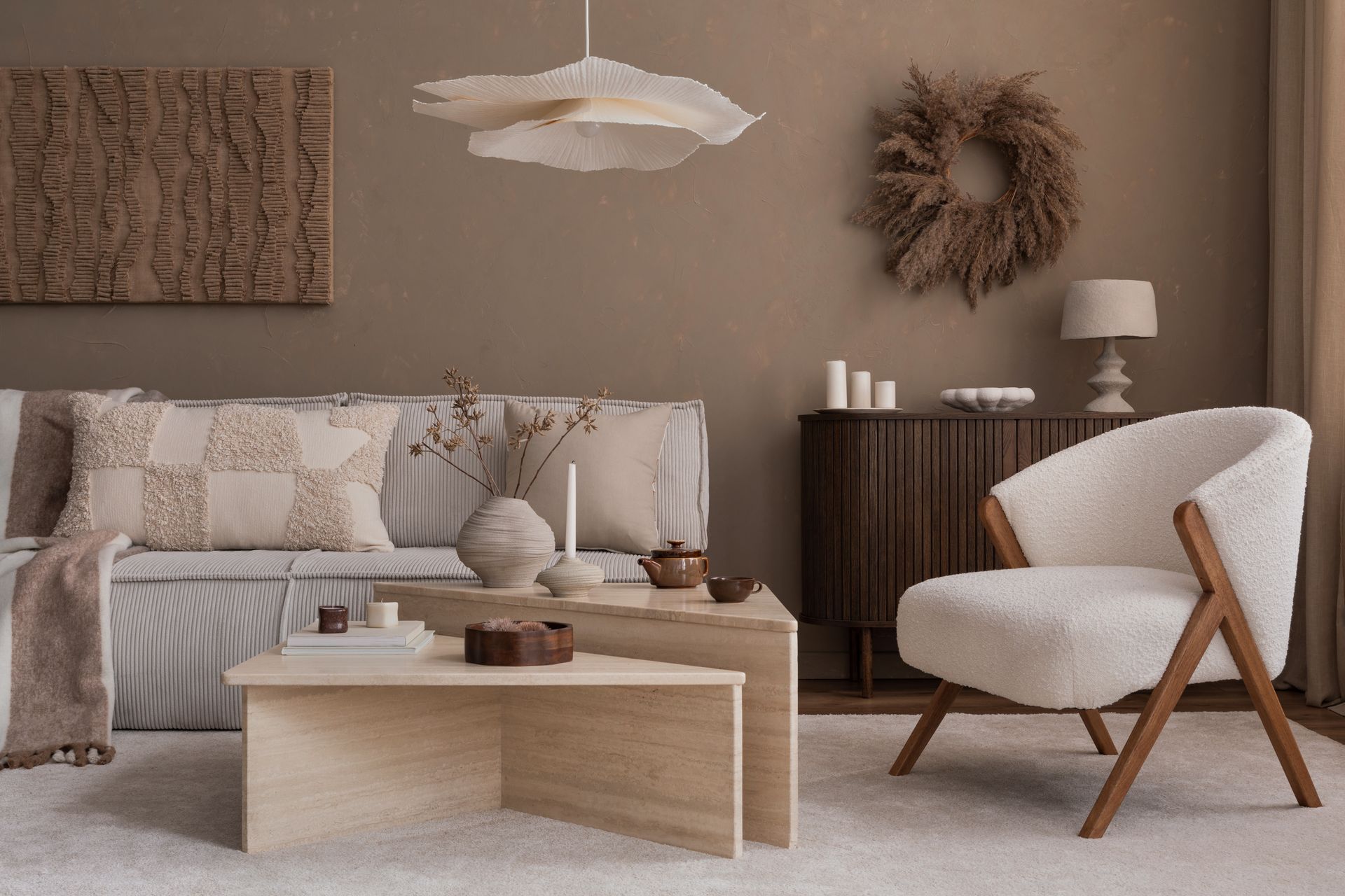Salon beige cosy avec canapé, table basse, fauteuil et décoration naturelle