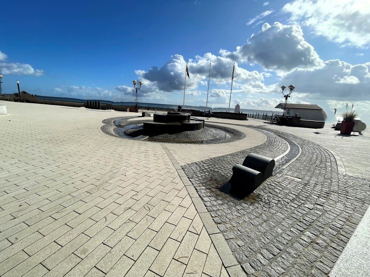 ein gemauerter Gehweg mit einem Brunnen in der Mitte
