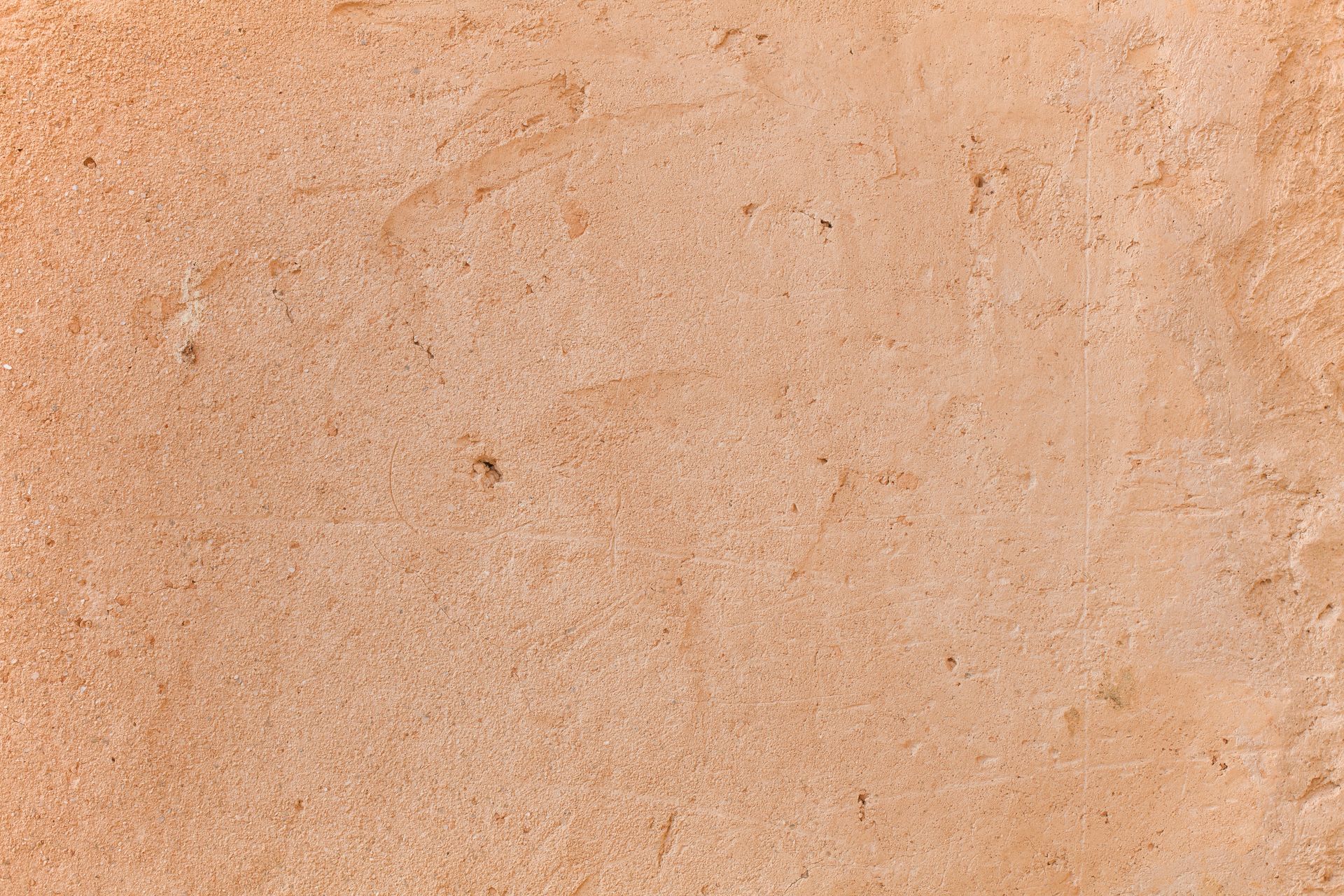 Primer plano de una pared texturizada de color marrón claro con algunas pequeñas motas.
