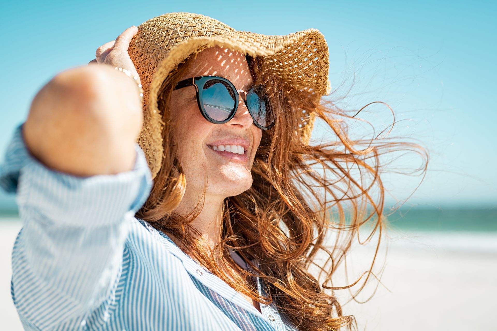 Une femme avec un chapeau et des lunettes
