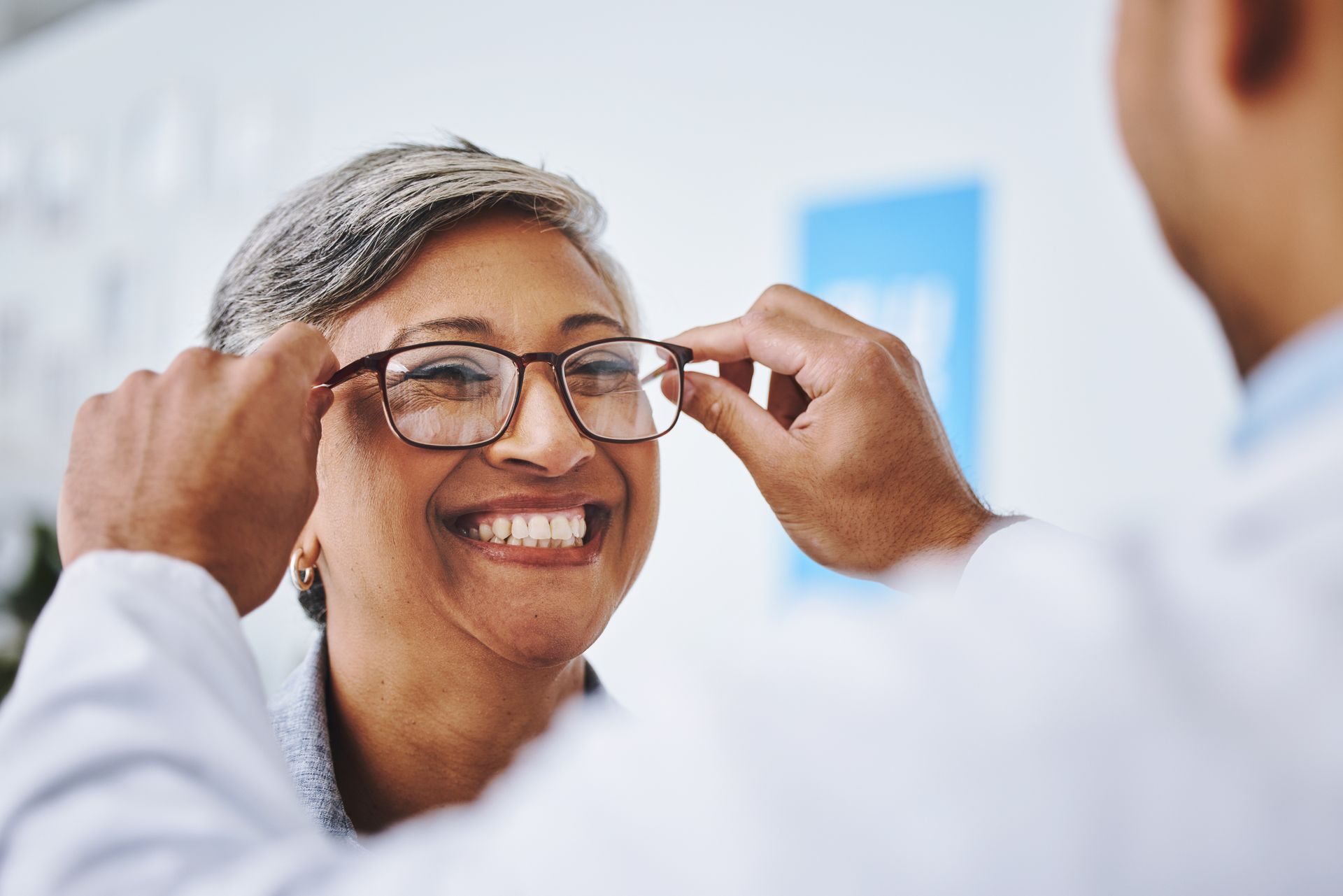 Une femme à qui on dépose des lunettes sur le nez