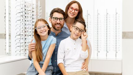 Une famille devant des lunettes en exposition