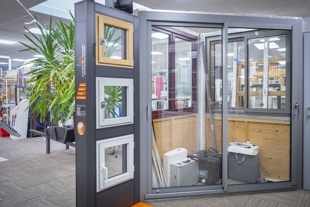 Bureau vitré avec structure noire, boiseries et équipement de bureau à l’intérieur