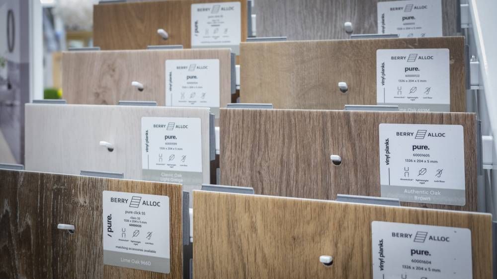 Des caisses en bois empilées, portant des étiquettes blanches, sont disposées sur des étagères dans un magasin