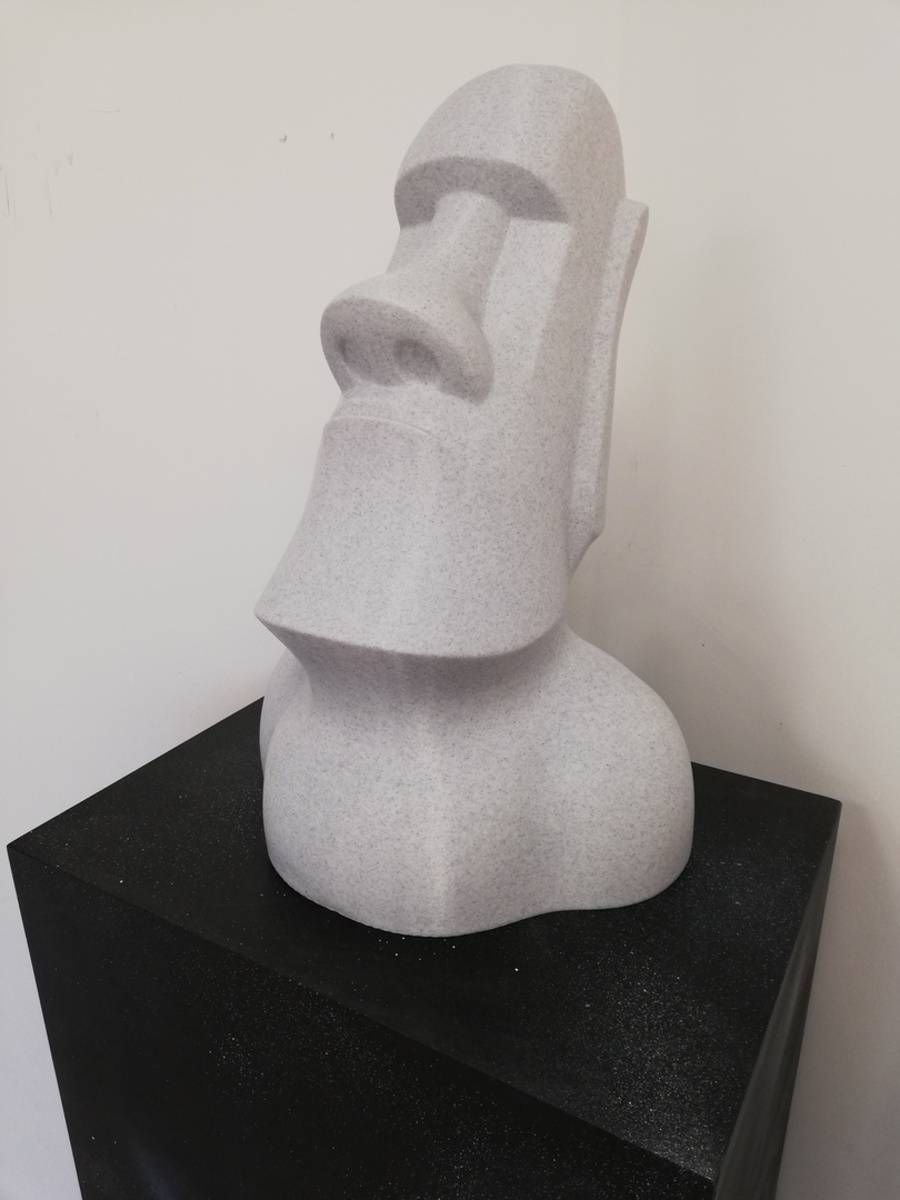 Buste blanc sculpté au long nez, posé sur un socle noir devant un mur uni