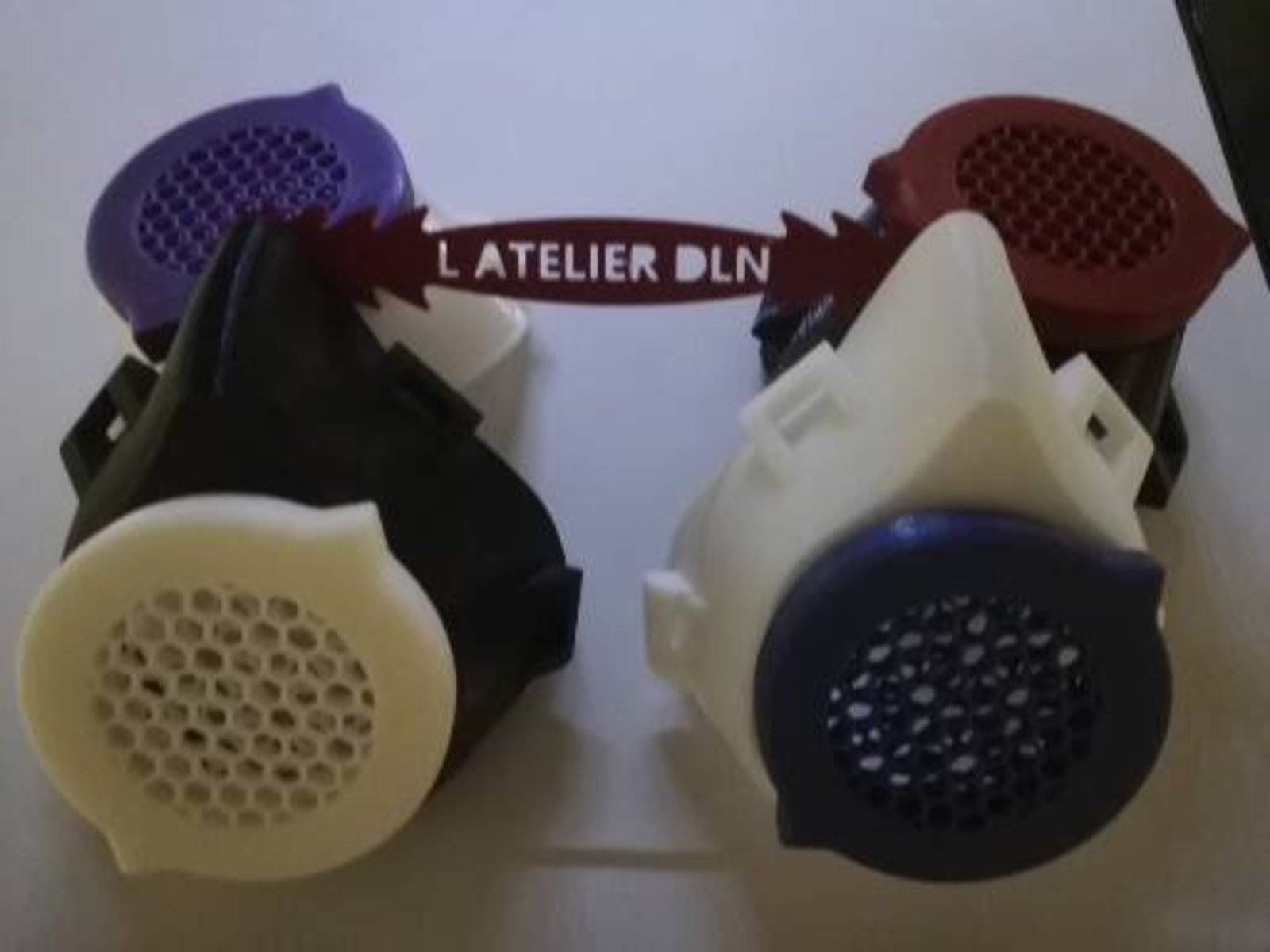 Quatre petits masques pour le visage violets, bordeaux, noirs et blancs disposés autour d’une étiquette indiquant « L’ATELIER DLN »