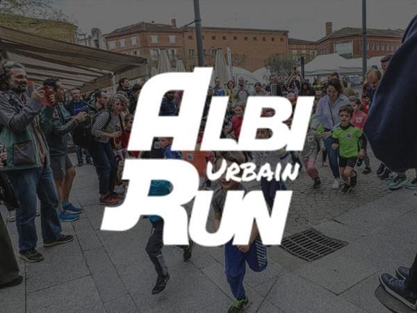 Logo ALBI Urban Run au-dessus de coureurs sur une place de ville, avec des spectateurs