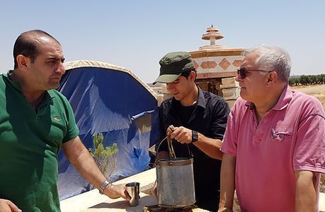 Eine Gruppe Männer gräbt mit Schaufeln im Dreck.