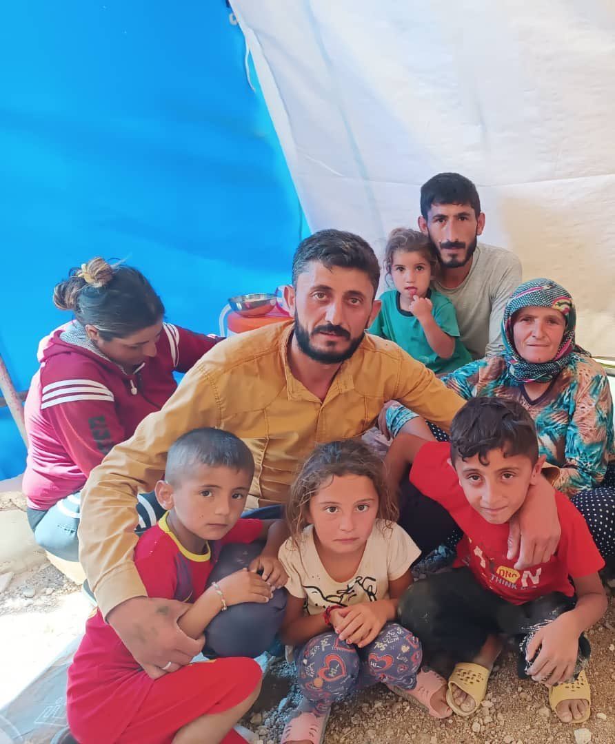 Eine Gruppe von Menschen posiert für ein Foto vor einem Zelt