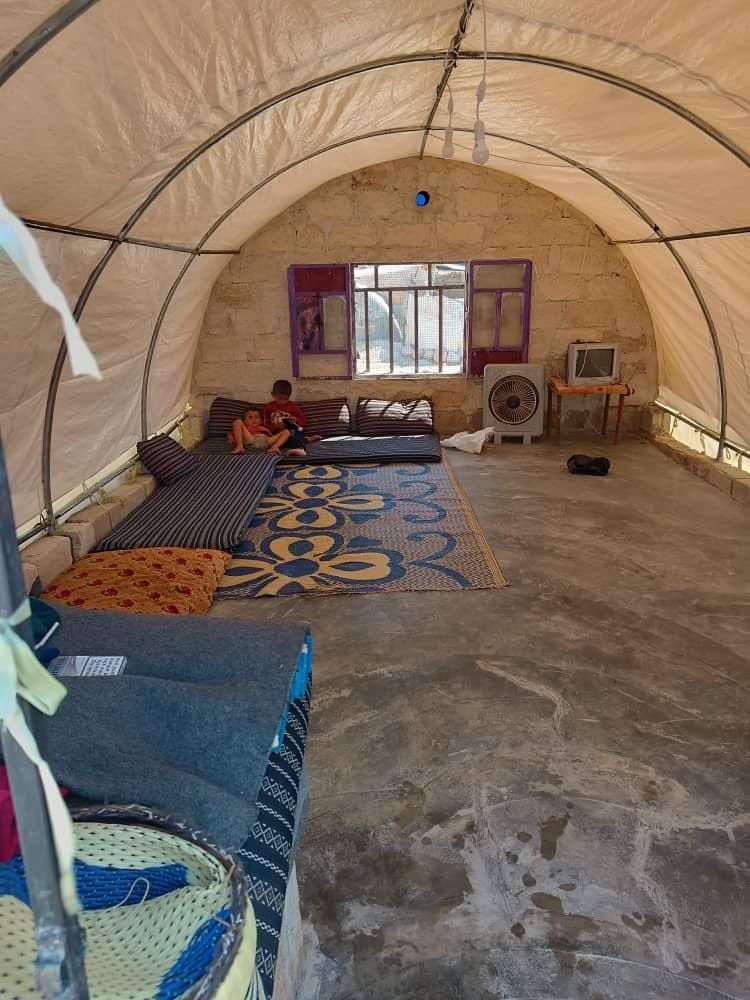 Ein Zelt mit einer Couch und einem Ventilator darin