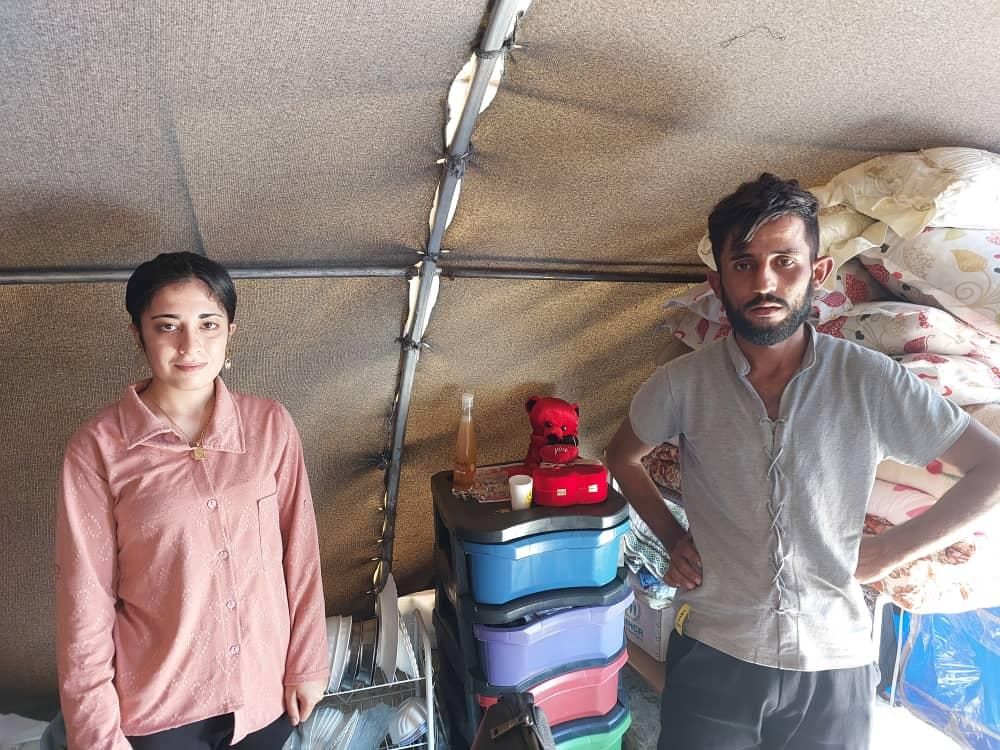 Ein Mann und eine Frau stehen nebeneinander in einem Zelt.