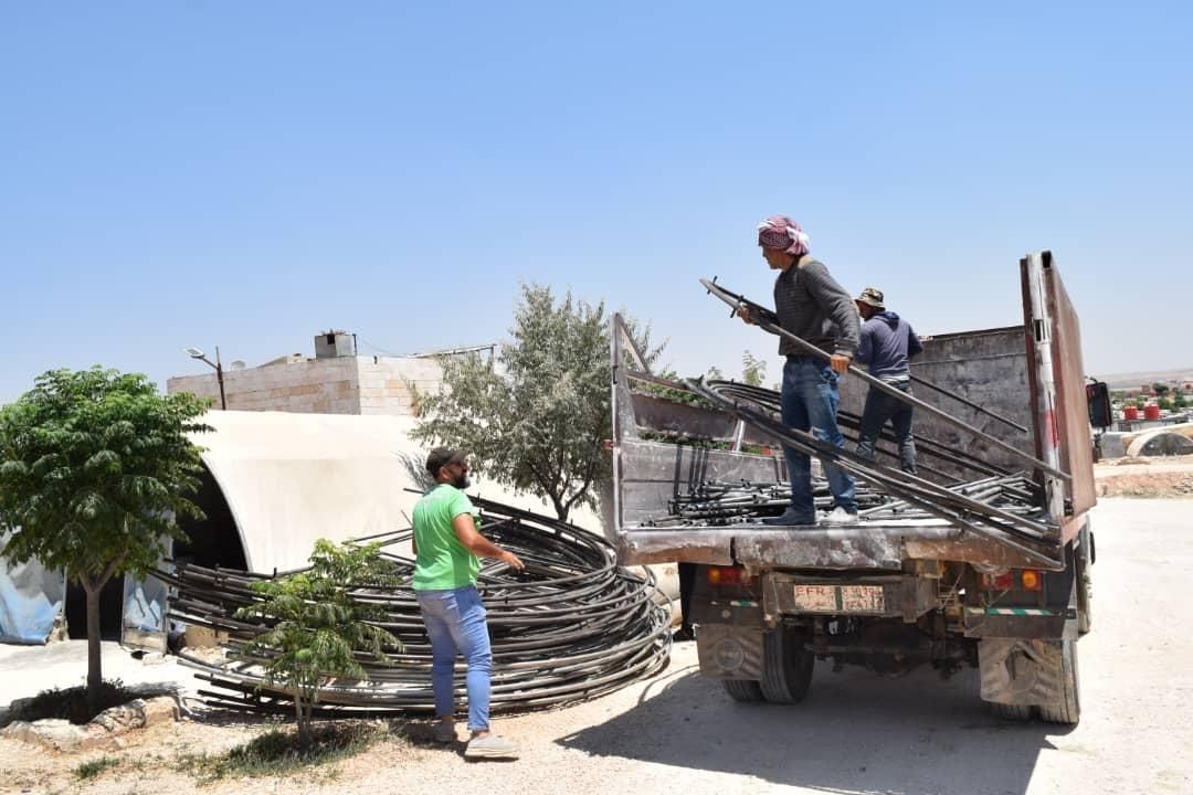 Ein Mann steht auf der Ladefläche eines Lastwagens.