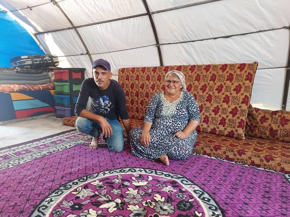 Ein Mann und eine Frau sitzen auf einem Sofa in einem Zelt.