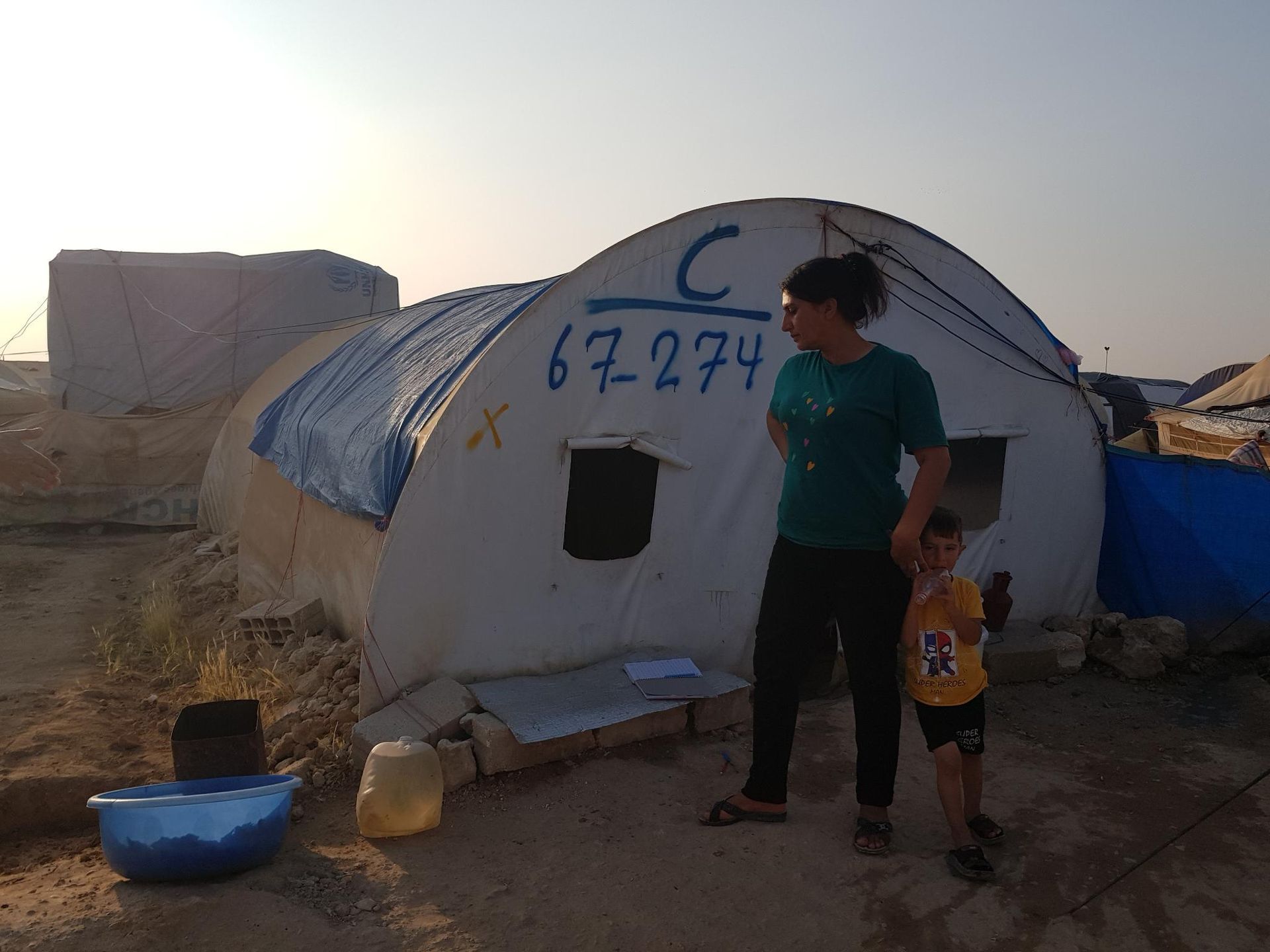 Frau und Kind vor Flüchtlingszelt