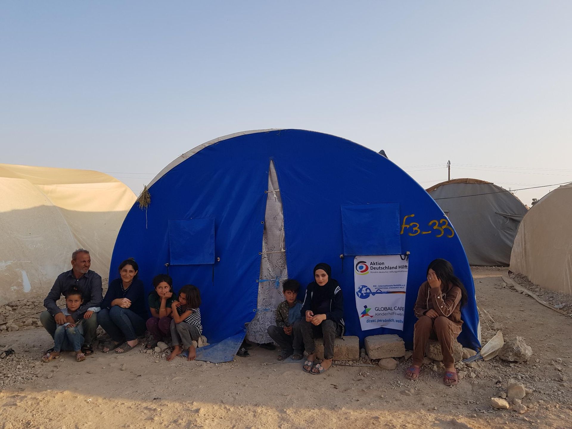 8 Personen vor einem Zelt