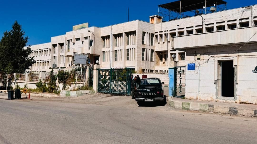 Einfahrtstor zum Hospital Derîk und schwarzer Pickup